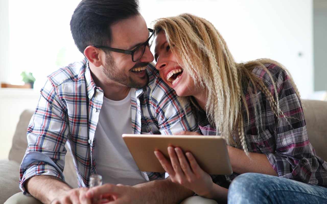 casal usando tablet feliz criando seu site de casamento