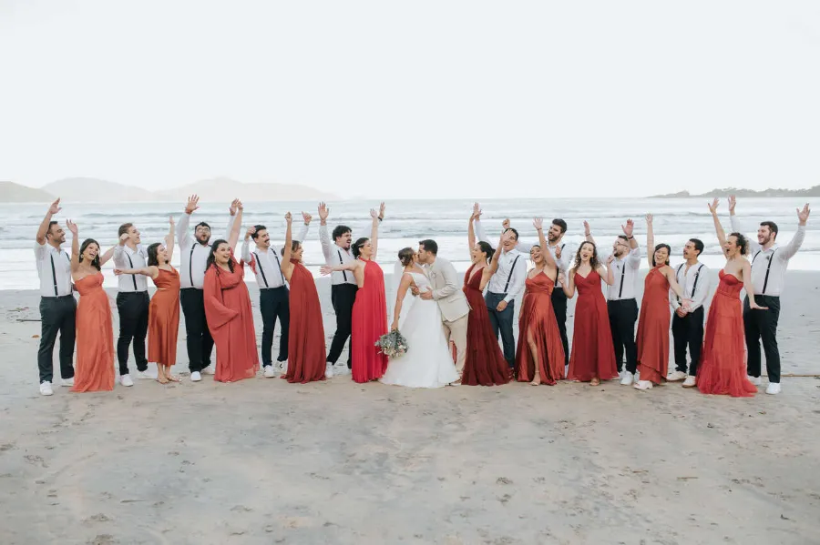 noivos se beijando ao lado de madrinhas e padrinhos