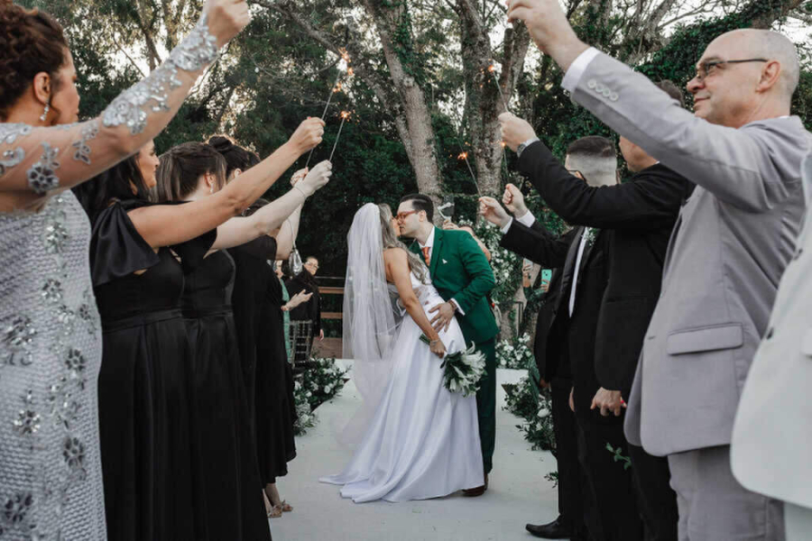 noivos se beijando na saída da cerimônia de casamento ao ar livre