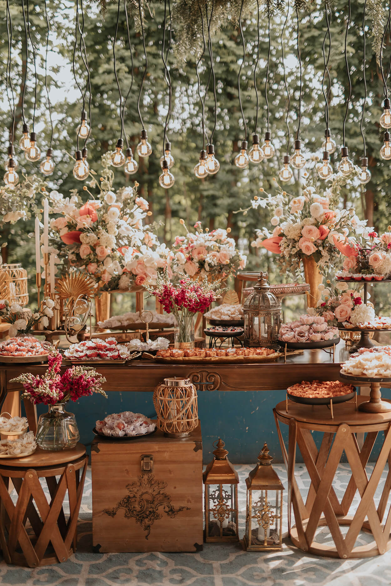 mesas com bolo de casamento com vasos de flores brancas e rosas