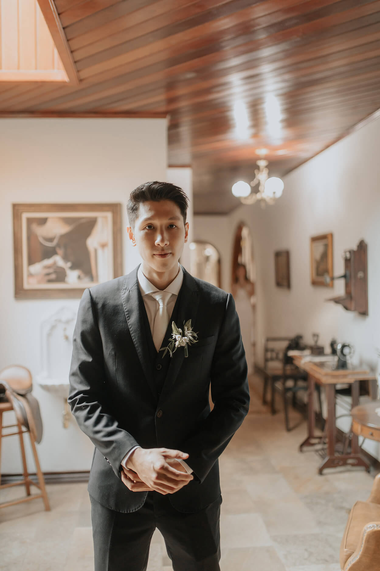 Noivo com terno preto aguardando a entrada da noiva no quarto