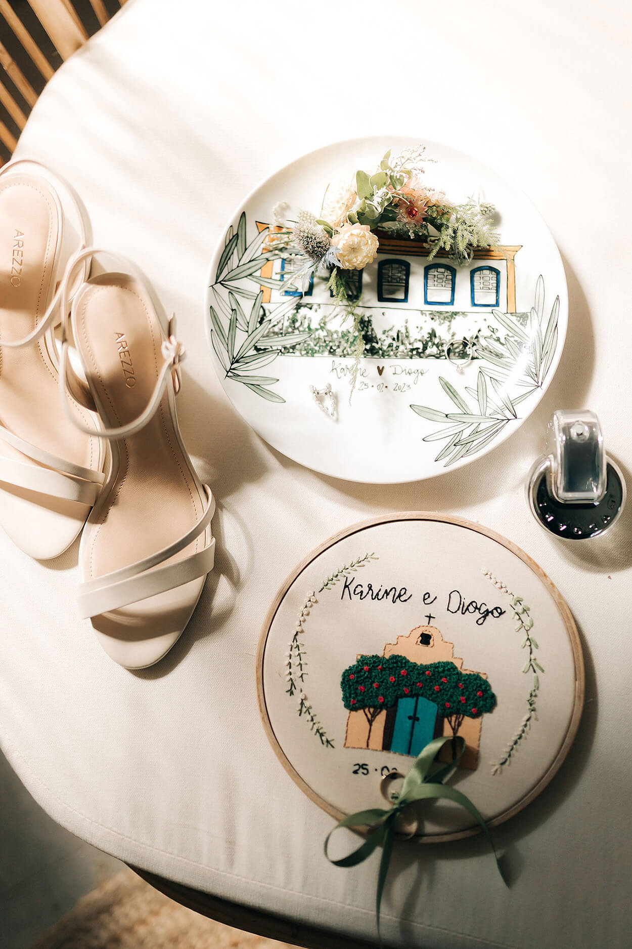 Mesa com sandalia branca prato decorado com flores e porta aliança bordado