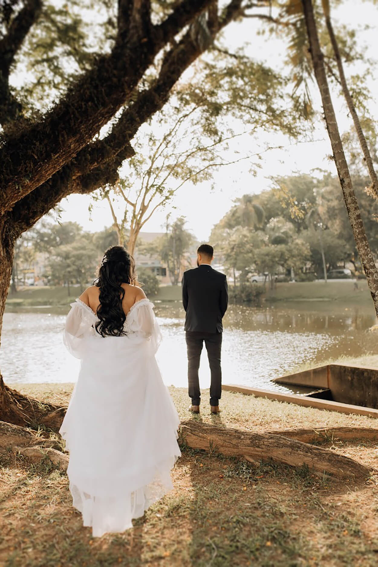 Noiva caminahndo até o noivo na beira do lago para fazer o first look