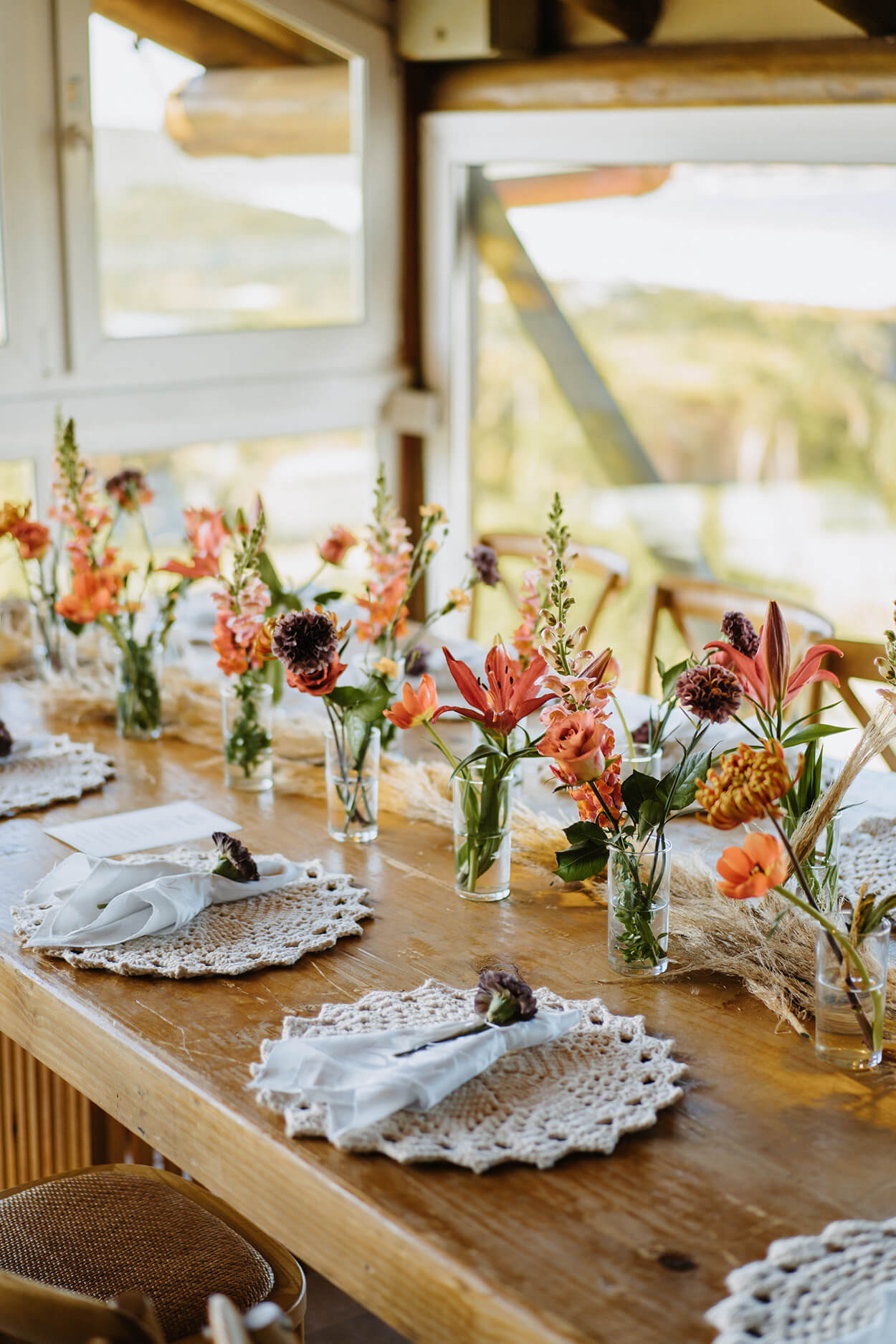 Mesa posta com lugar americando com croche e vasinhos com flores