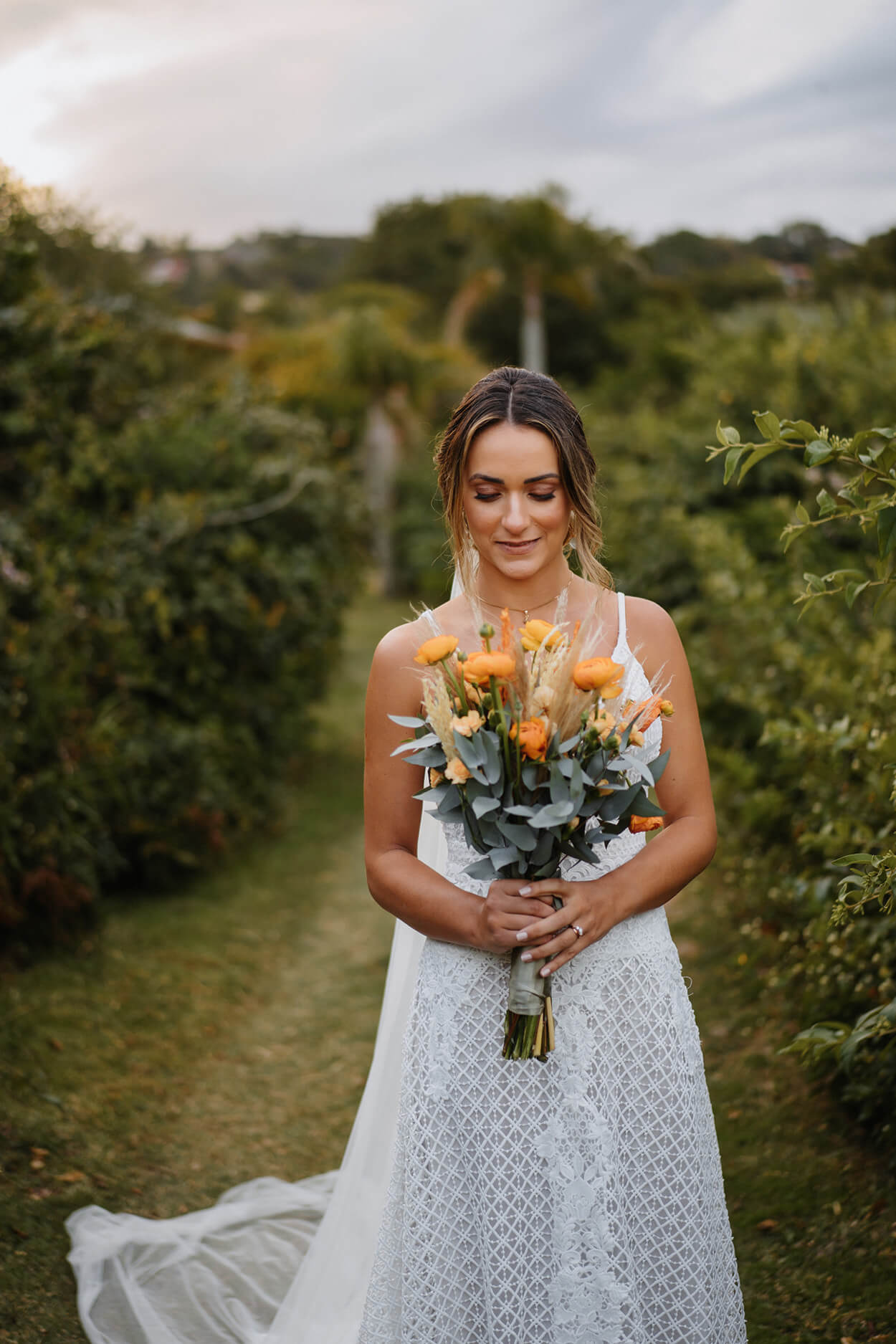 Mulher com vestido de noiva segurando buquê com flores amarelas