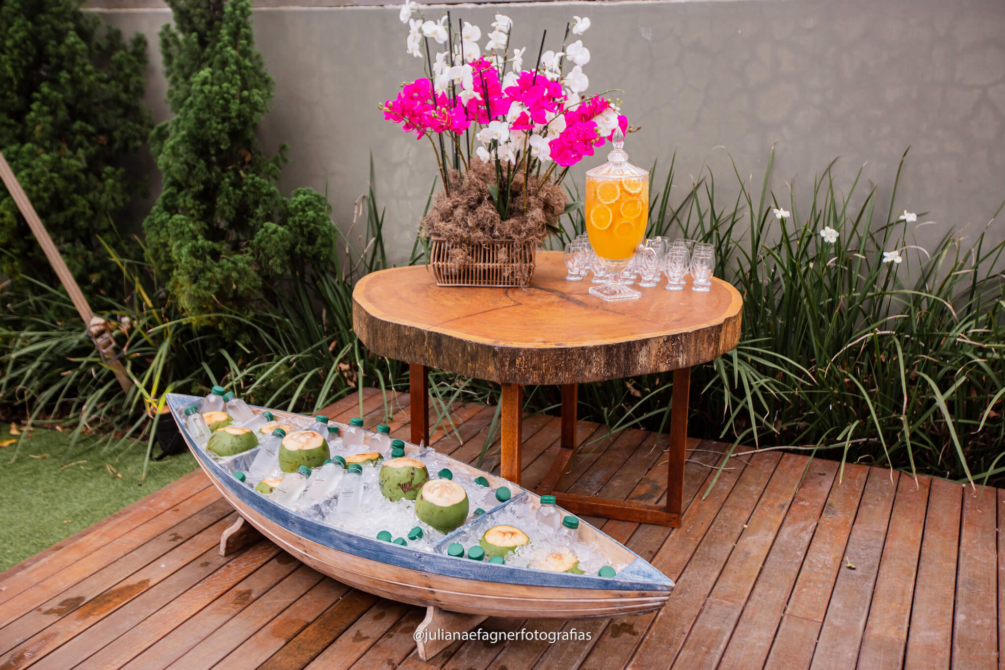 deck com barco decorativo com cocos verdes e mesa com suqueira de vidro