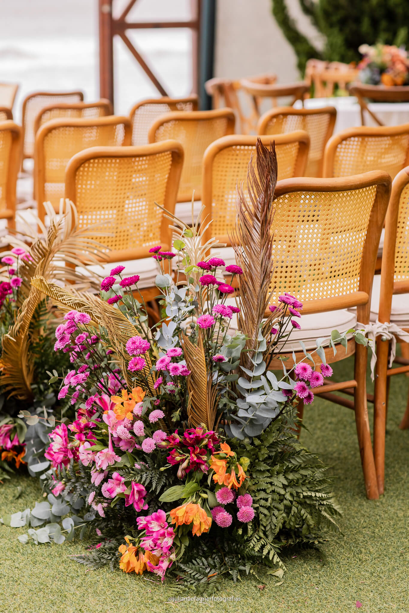 cadeiras com palhinha e arranjos com flores rosas e laranjas