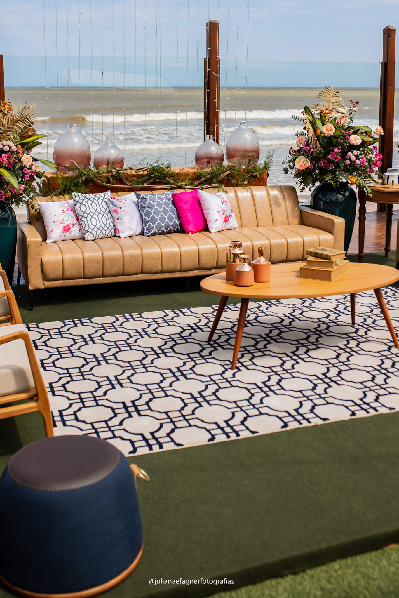 lounge no jardim de frente a praia com sofa bege e almofadas branca azuis e rosas