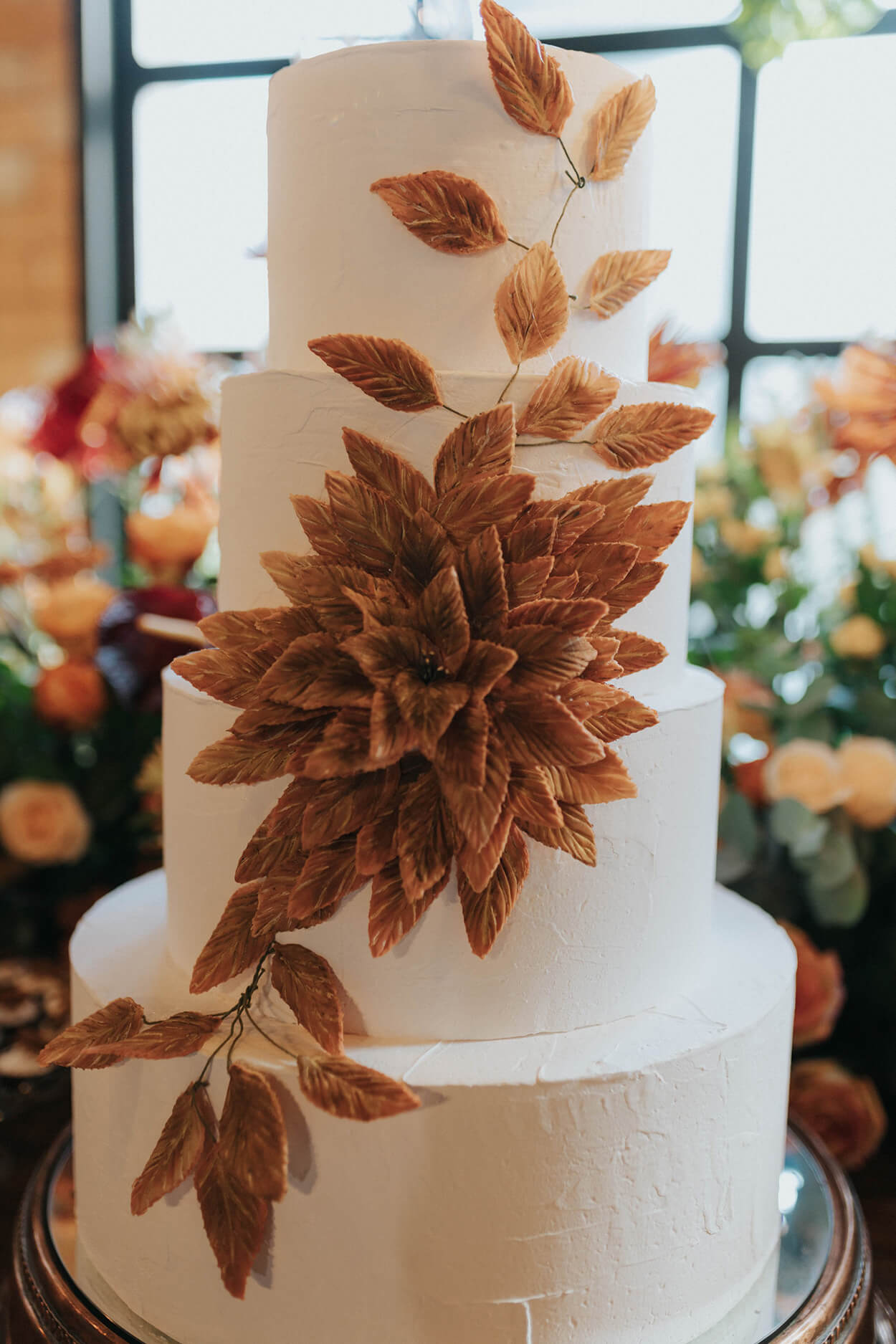 bolo de casamento branco com quatro andares com flores 