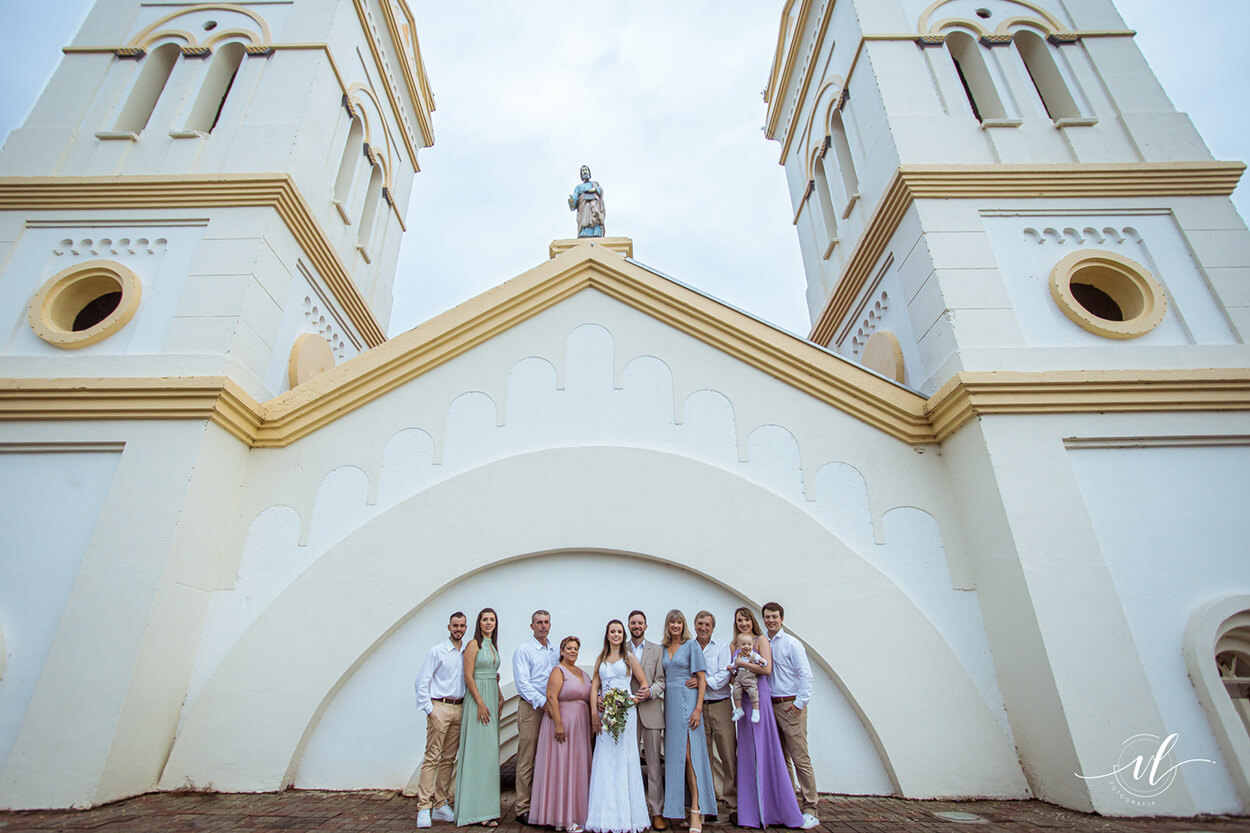 noivos e convidados em frente a igreja em itá
