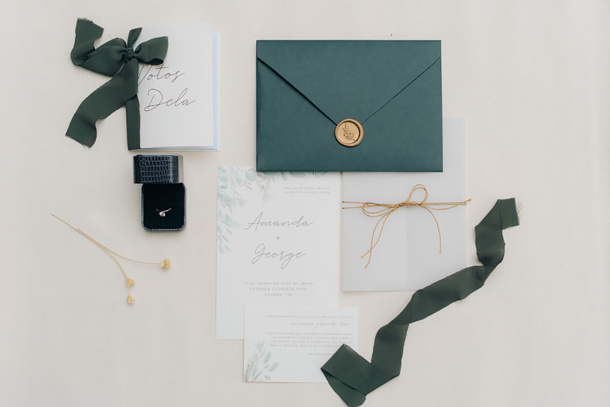 convite de casamento branco e verde sobre a mesa