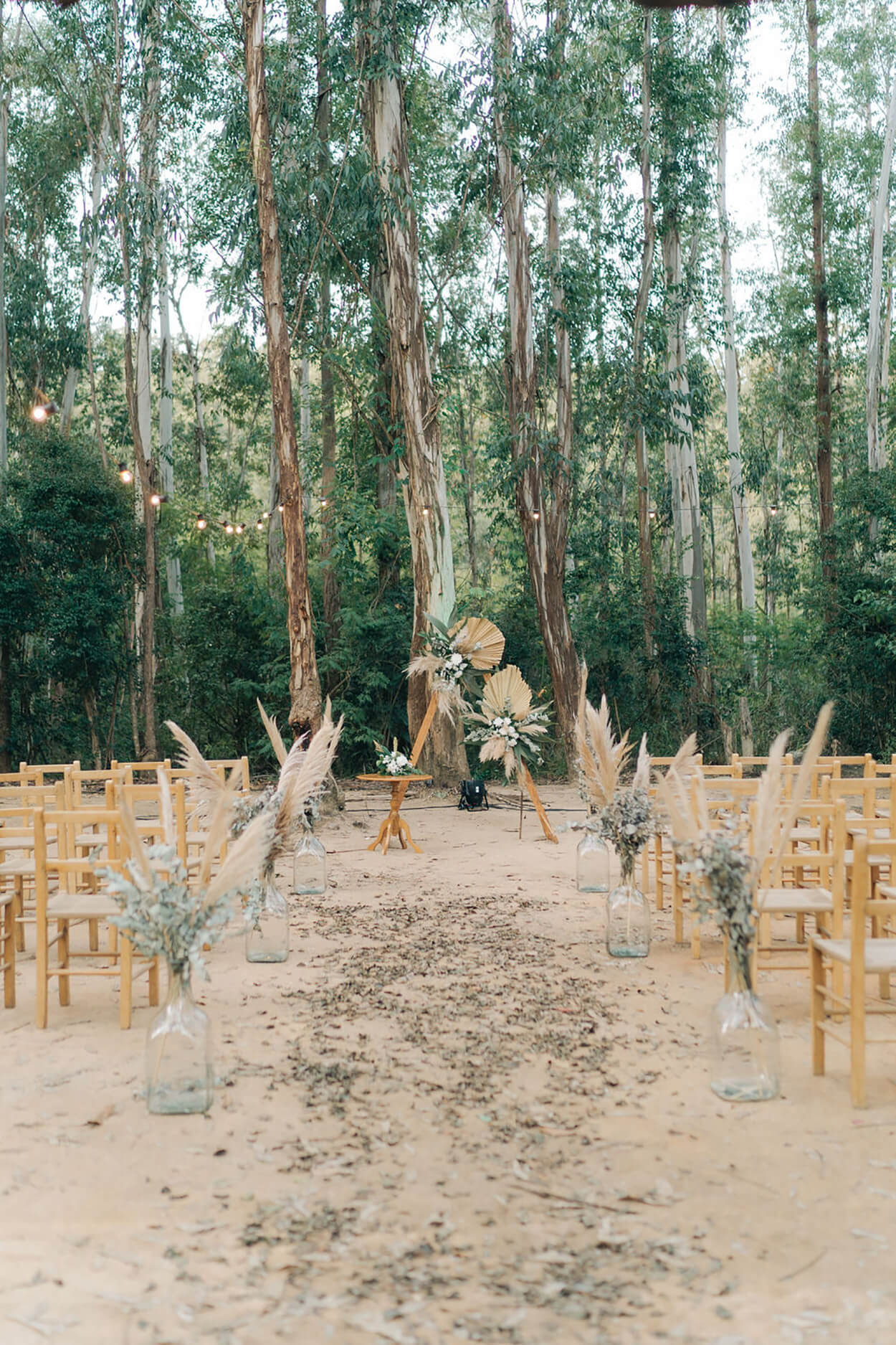 altar geométrico com arranjo com florexs e capim dos pampas na floresta de eucaliptos
