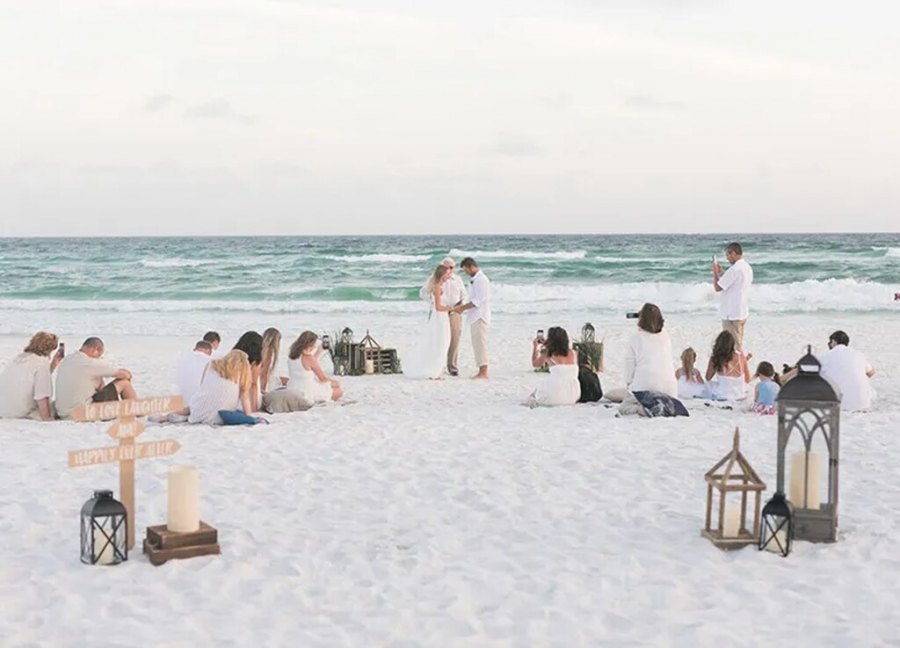 cerimônia de casamento ao ar livre na praia com convidados sentados na areia