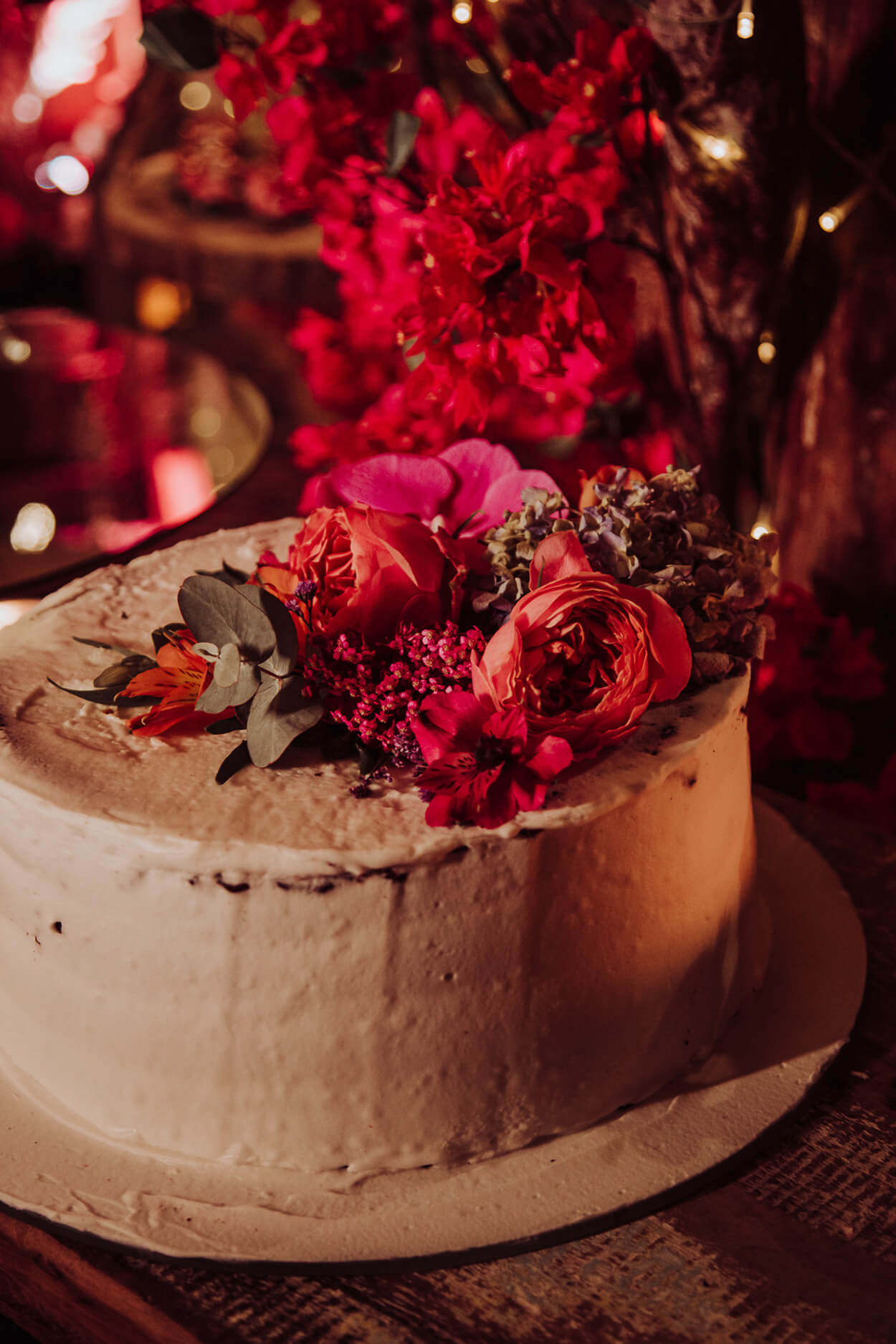 Bolo de casamento branco com topo com flores vermelhas e rosas