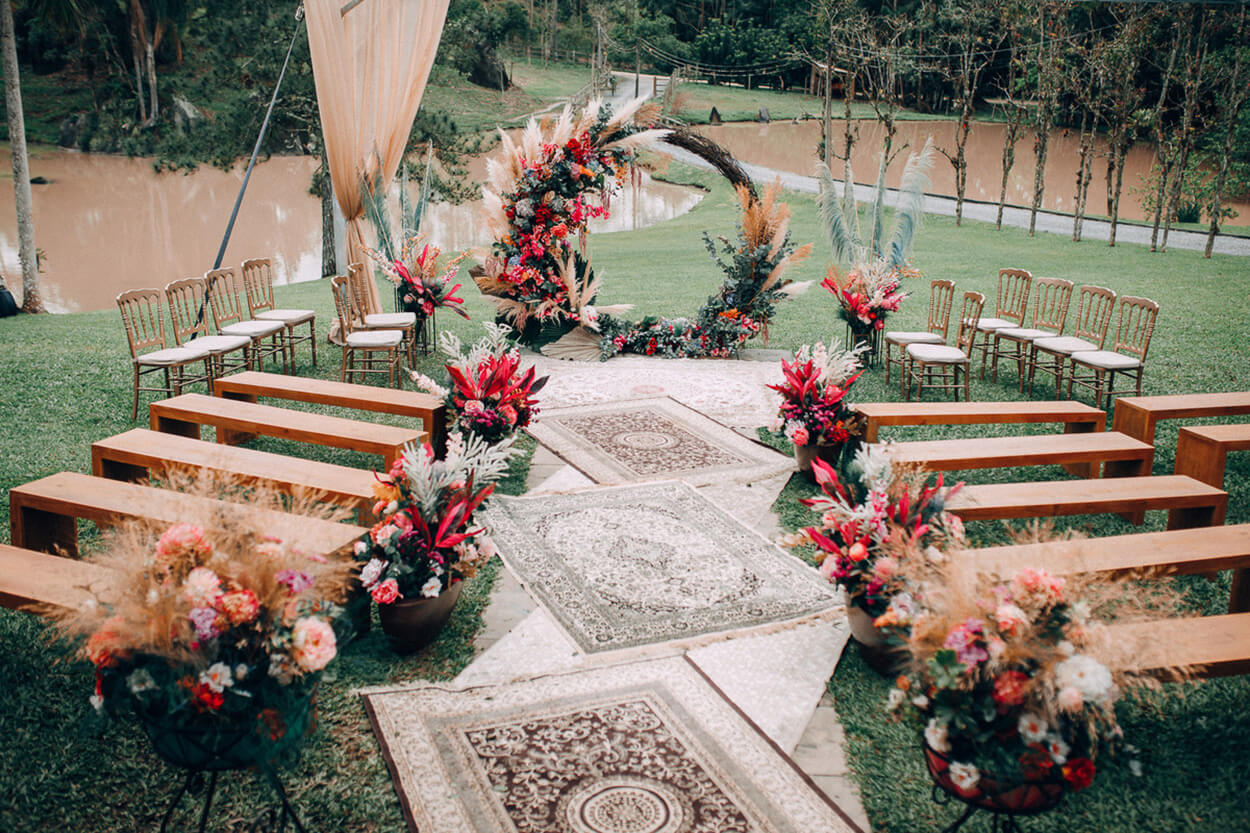 Altar com capim dos pampas e flores vermelhas brancas e laranjas