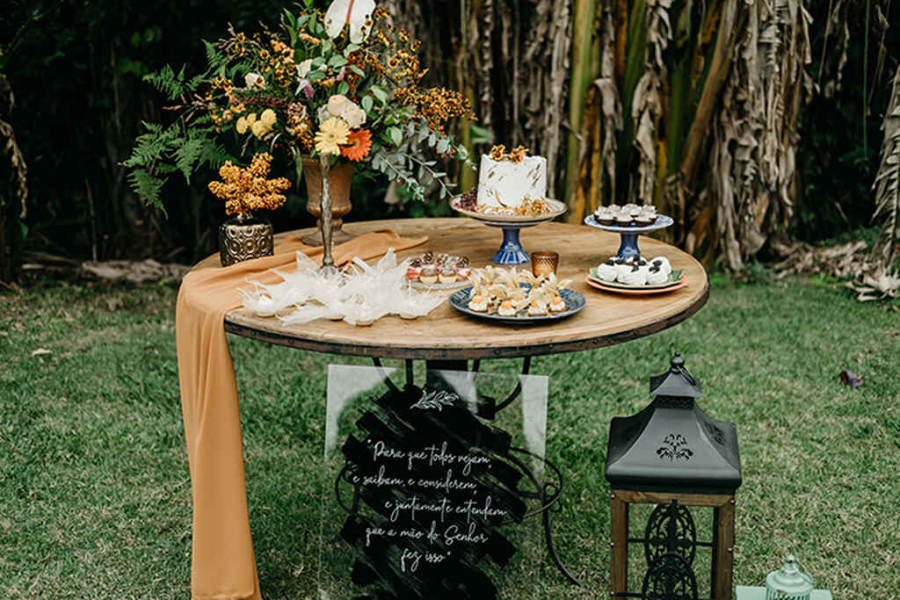 decoração rústica de mesa de bolo em casamento ao ar livre