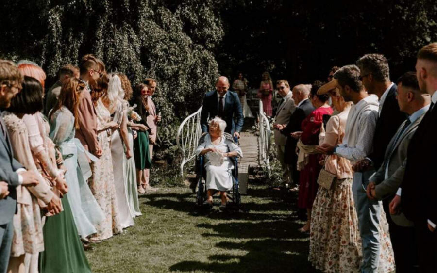 entradas das alianças com avó em cadeira de rodas em cerimônia ao ar livre