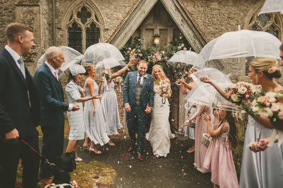 saída dos noivos em casamento ao ar livre com chuva