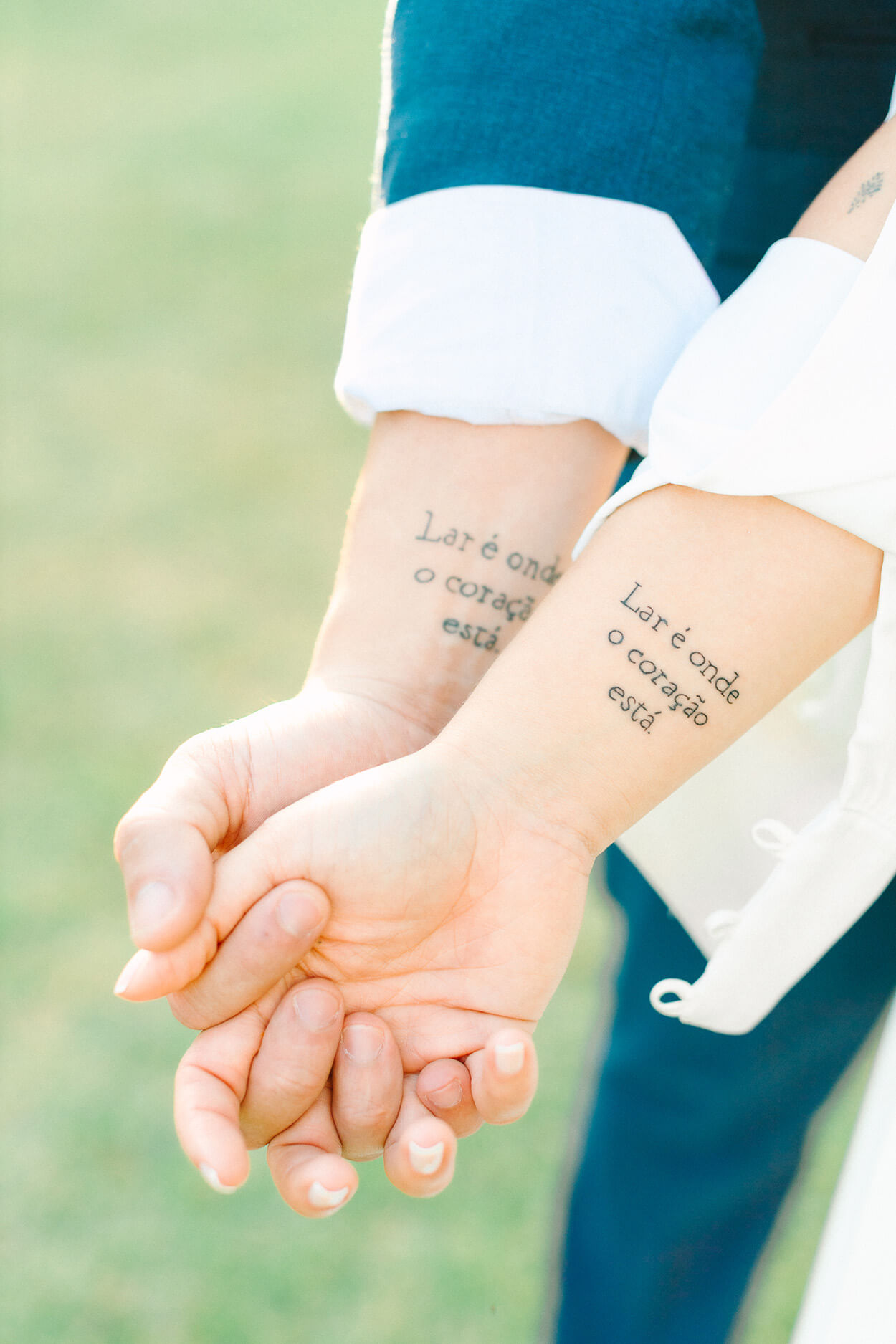 noivos de mãos dadas com tatuagem
