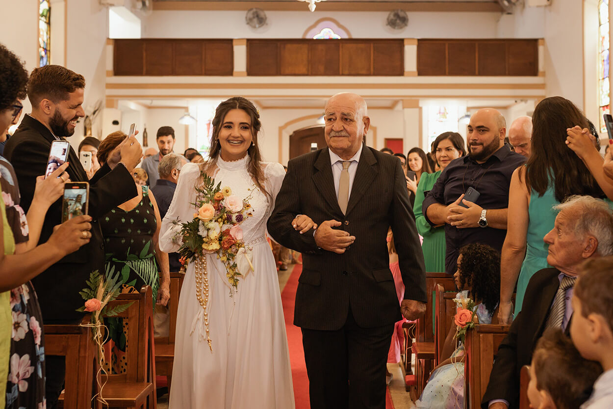 entrada da noiva ao lado do pai com terno preto no Casamento na igreja