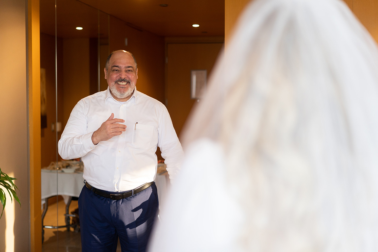pai com calça azul e camisa branca vendo a noiva pela primeira vez