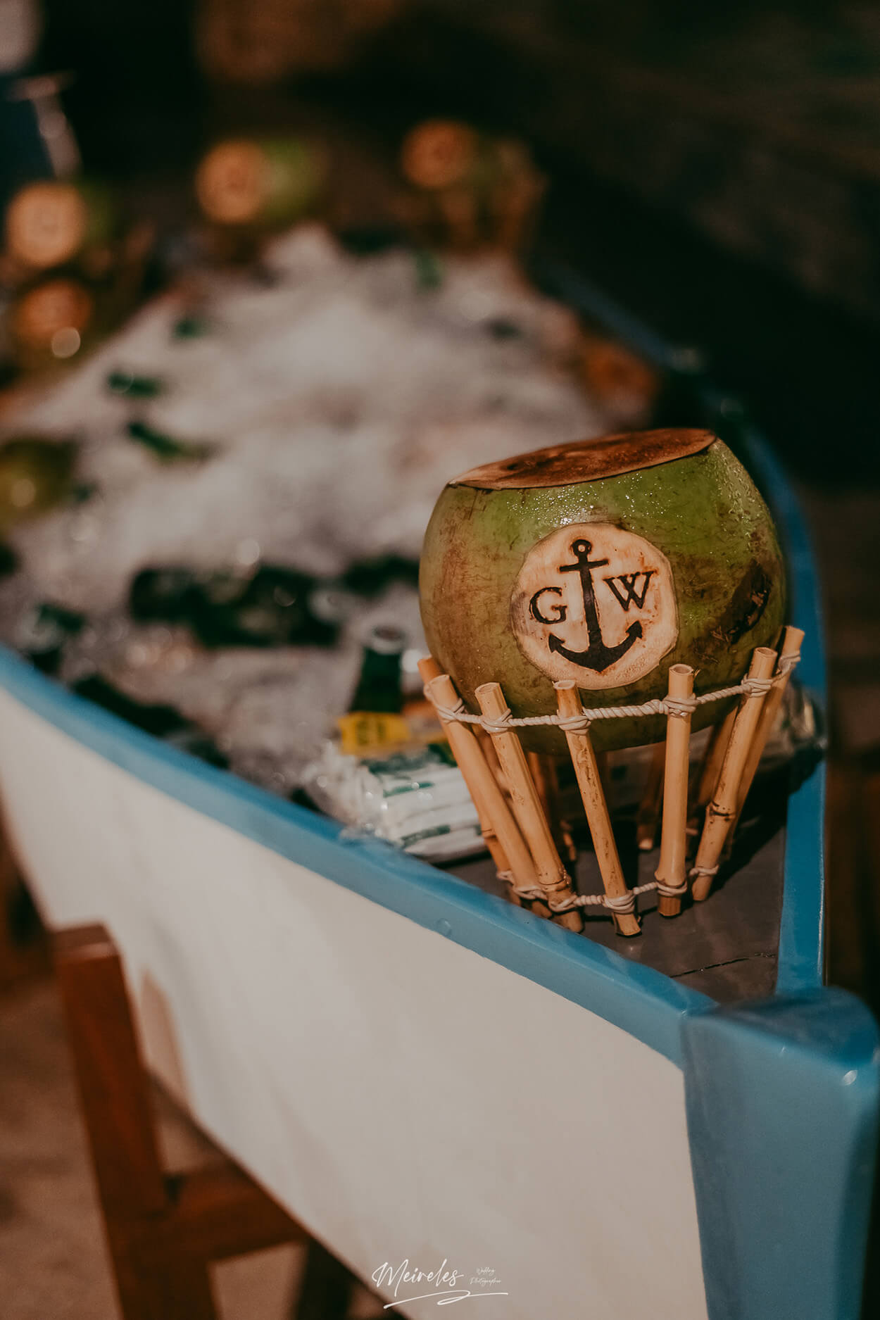 barco de madeira branco e azul com côco verde com as iniciais dos noivos