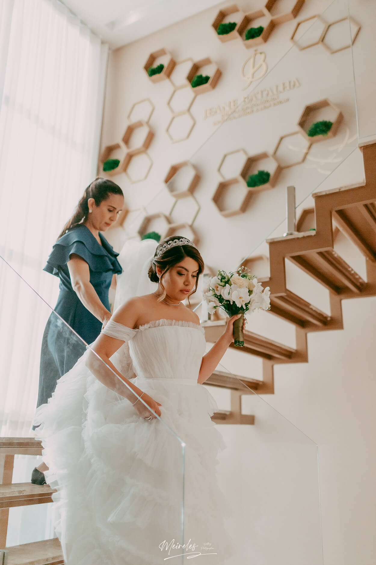 Noiva segurando um buquÊ de orquideas brancas descendo as escadas