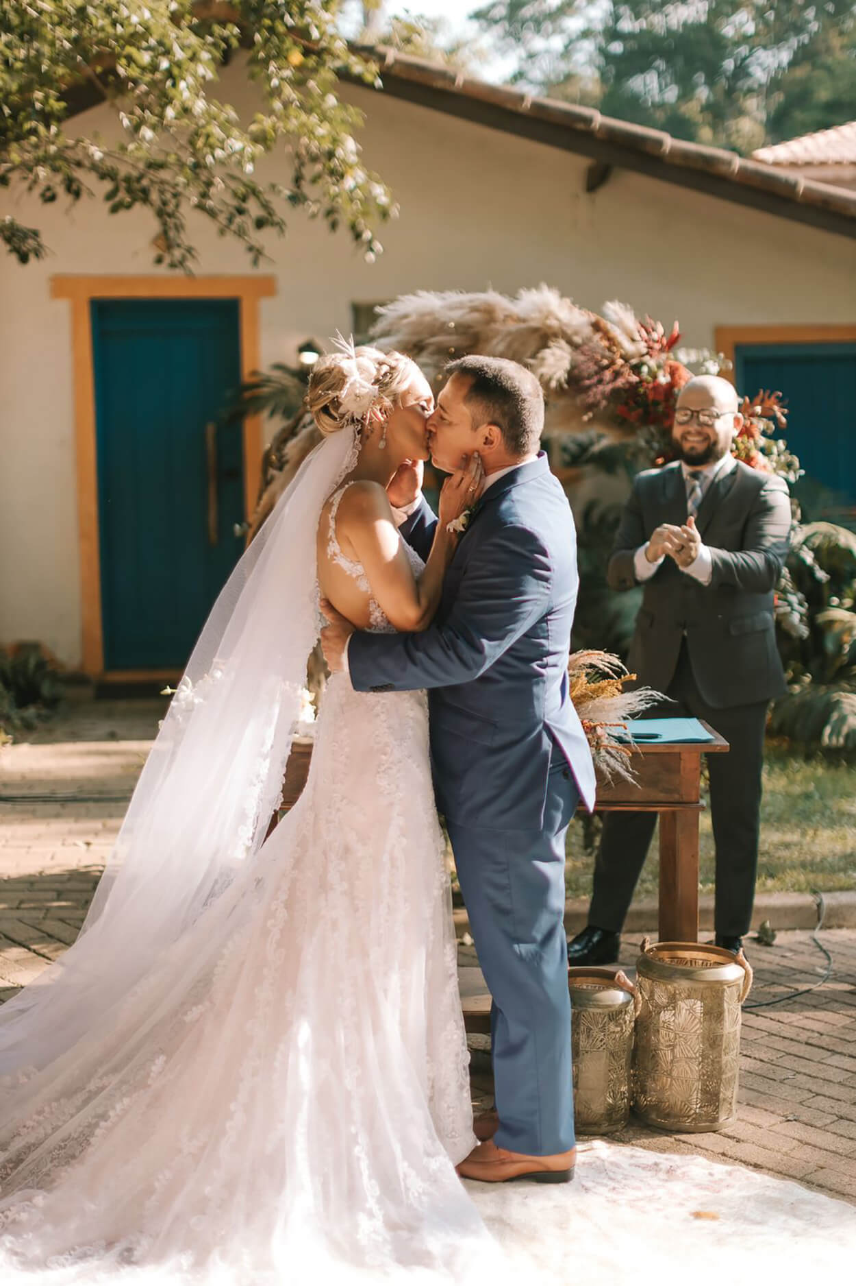 Noivos se beijando na cerimonia de casamento boho