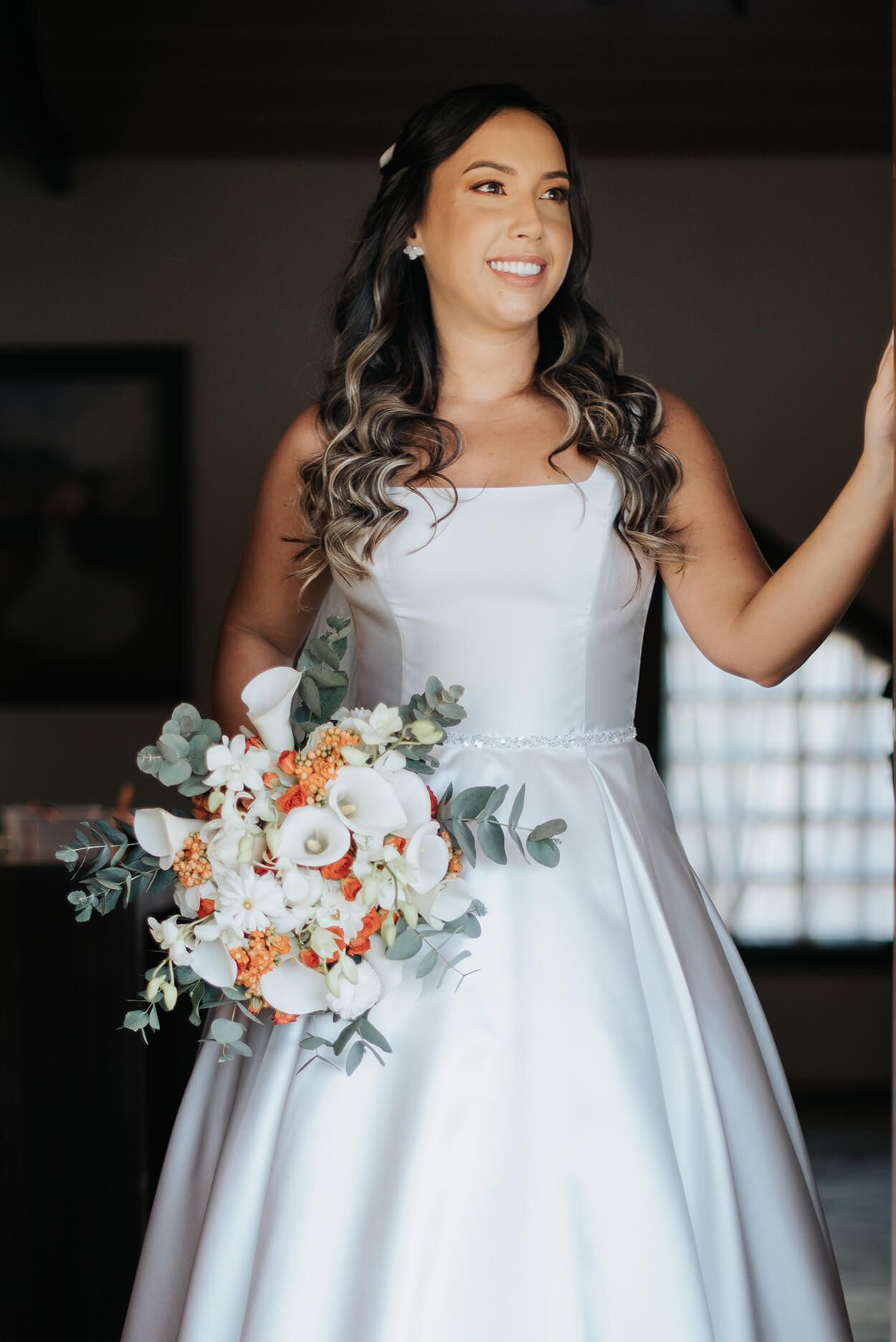 Vestido de noiva minimalista com decote quadrado e buquê com flores brancas e laranjas