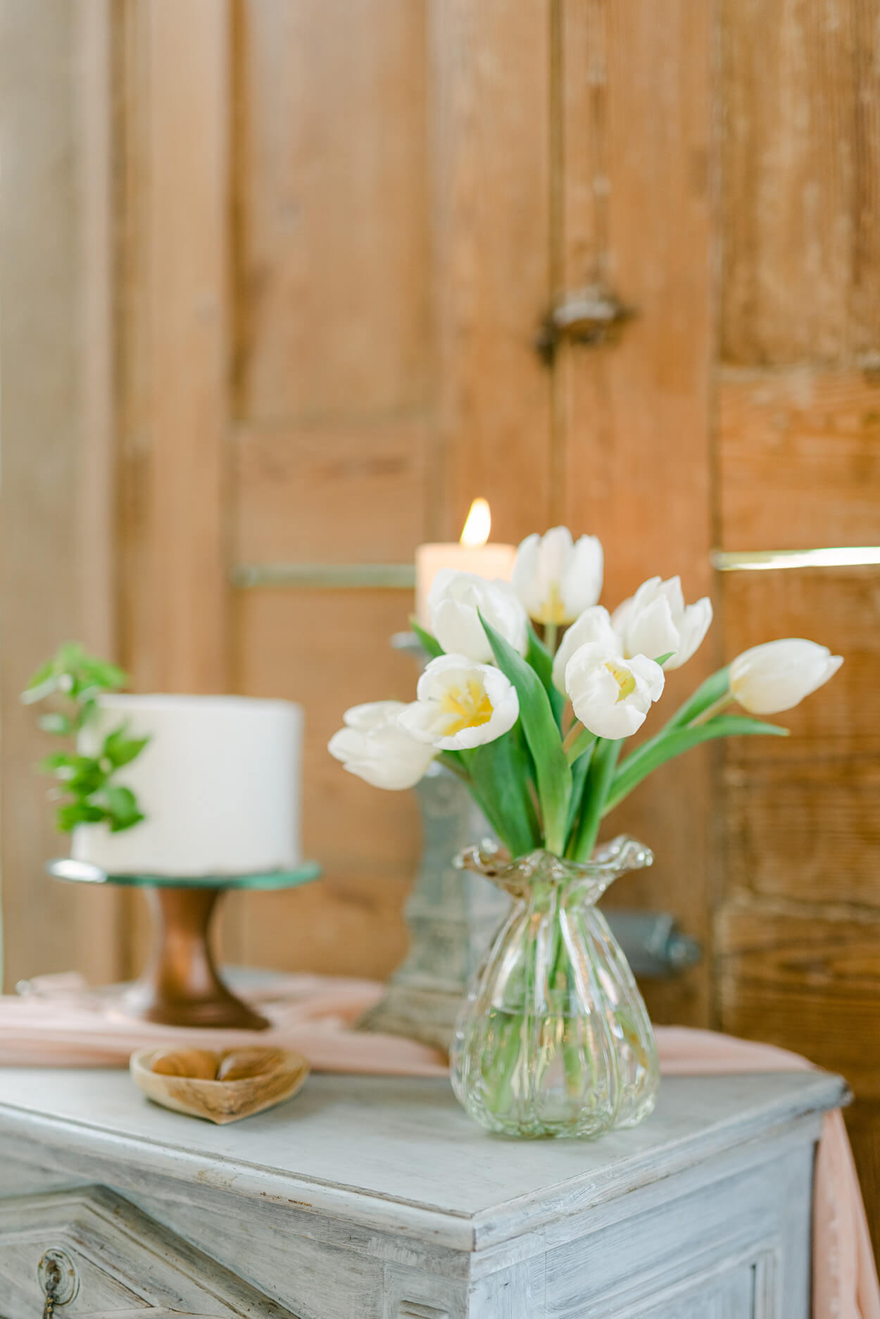 bolo branco e vaso com tulipas brancas
