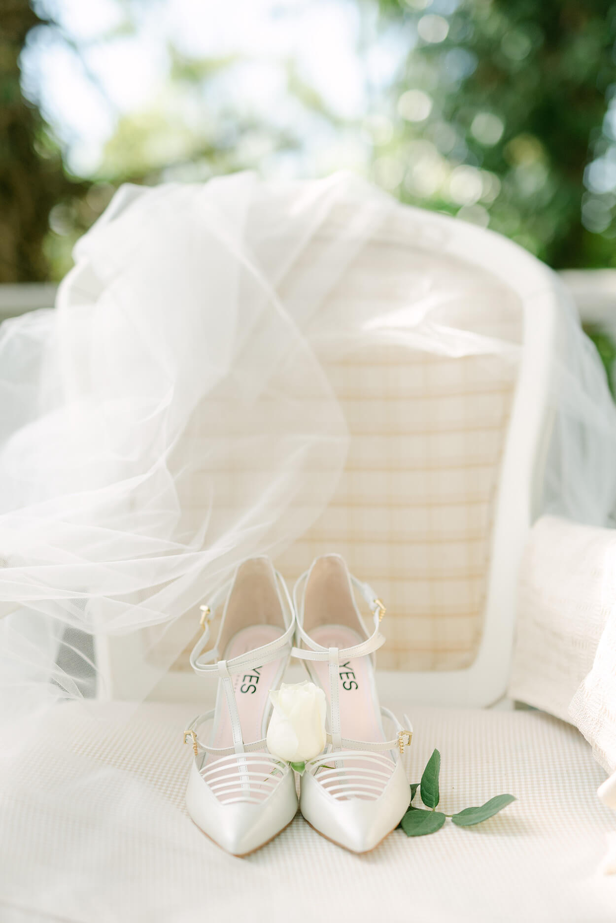 sandália de noiva branca em cima da cadeira