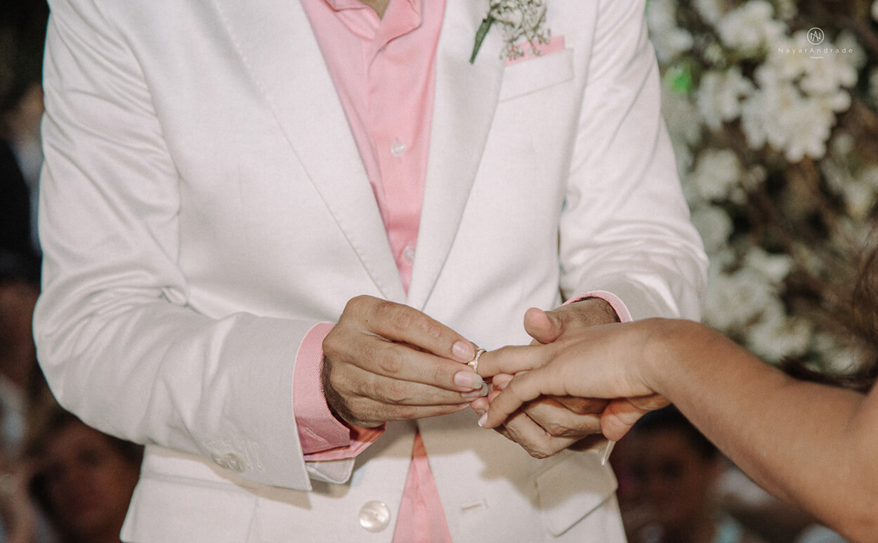Noivo colocando a aliança na mão da noiva