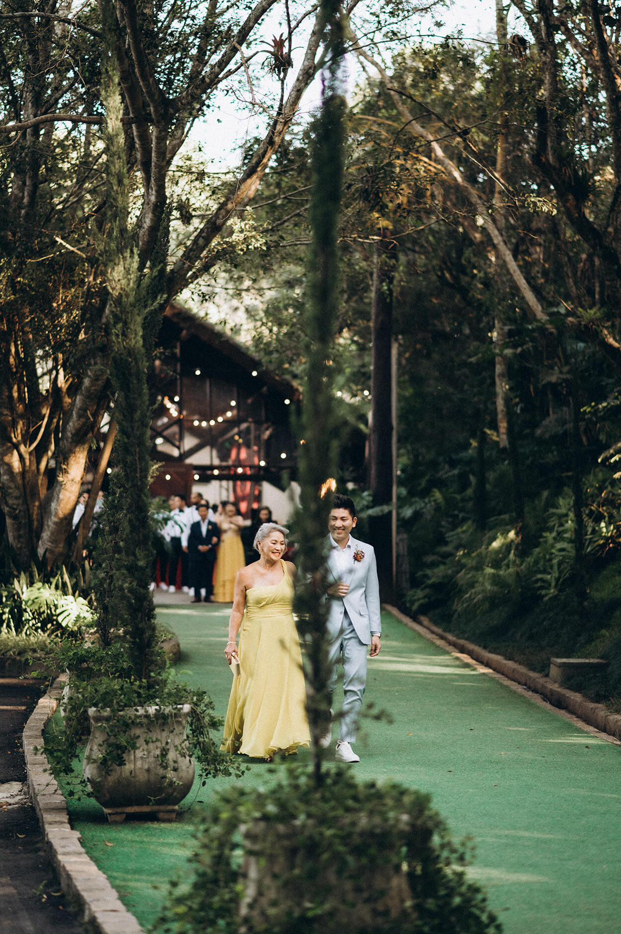 entrada do noivo com terno azul com mãe usando vestido amarelo