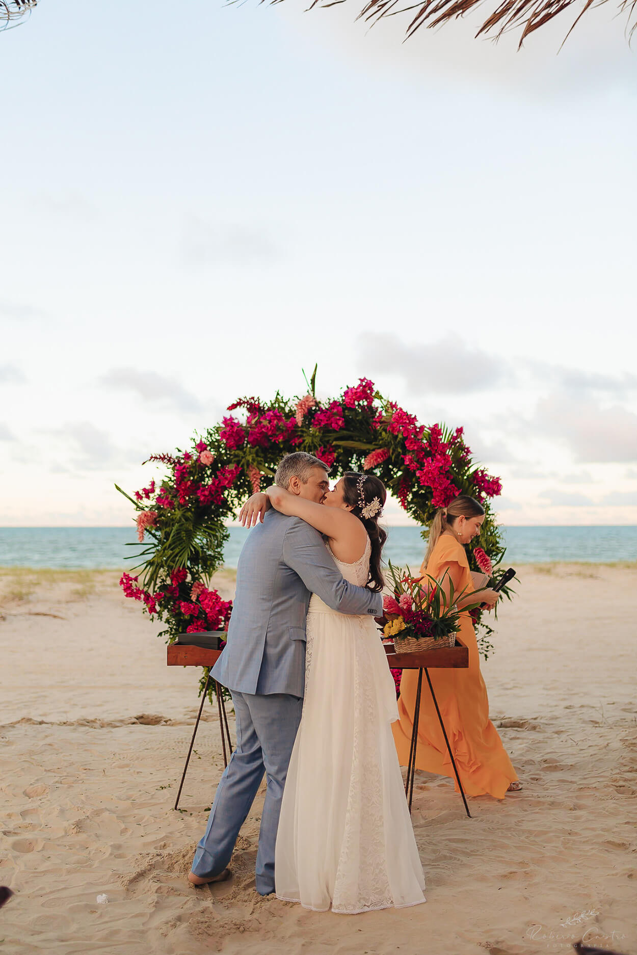 Noivos se beijando no altar na praia