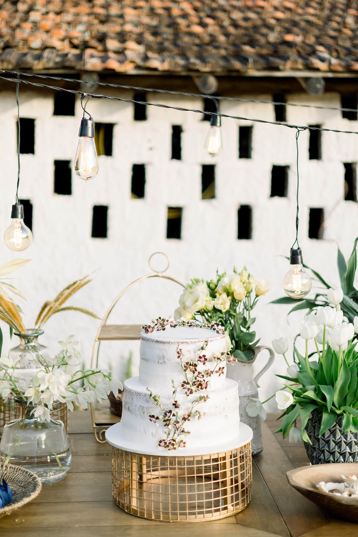 mesa com bolo de casamento de dois andares com flores