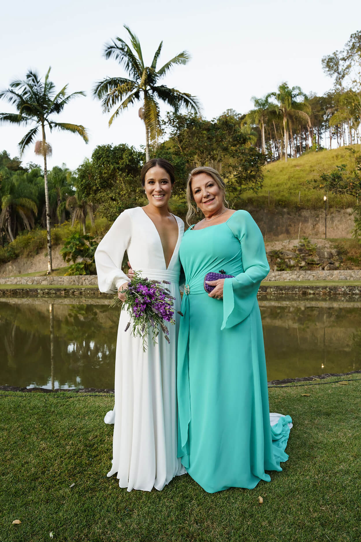 Mulher com vestido de noiva minimalist com decote em v ao lado d mãe com vetsido zul serenity