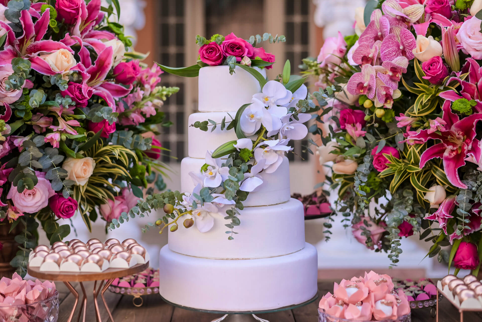 bolo de casamento com cinco andares com orquideas brancas com rosas no topo