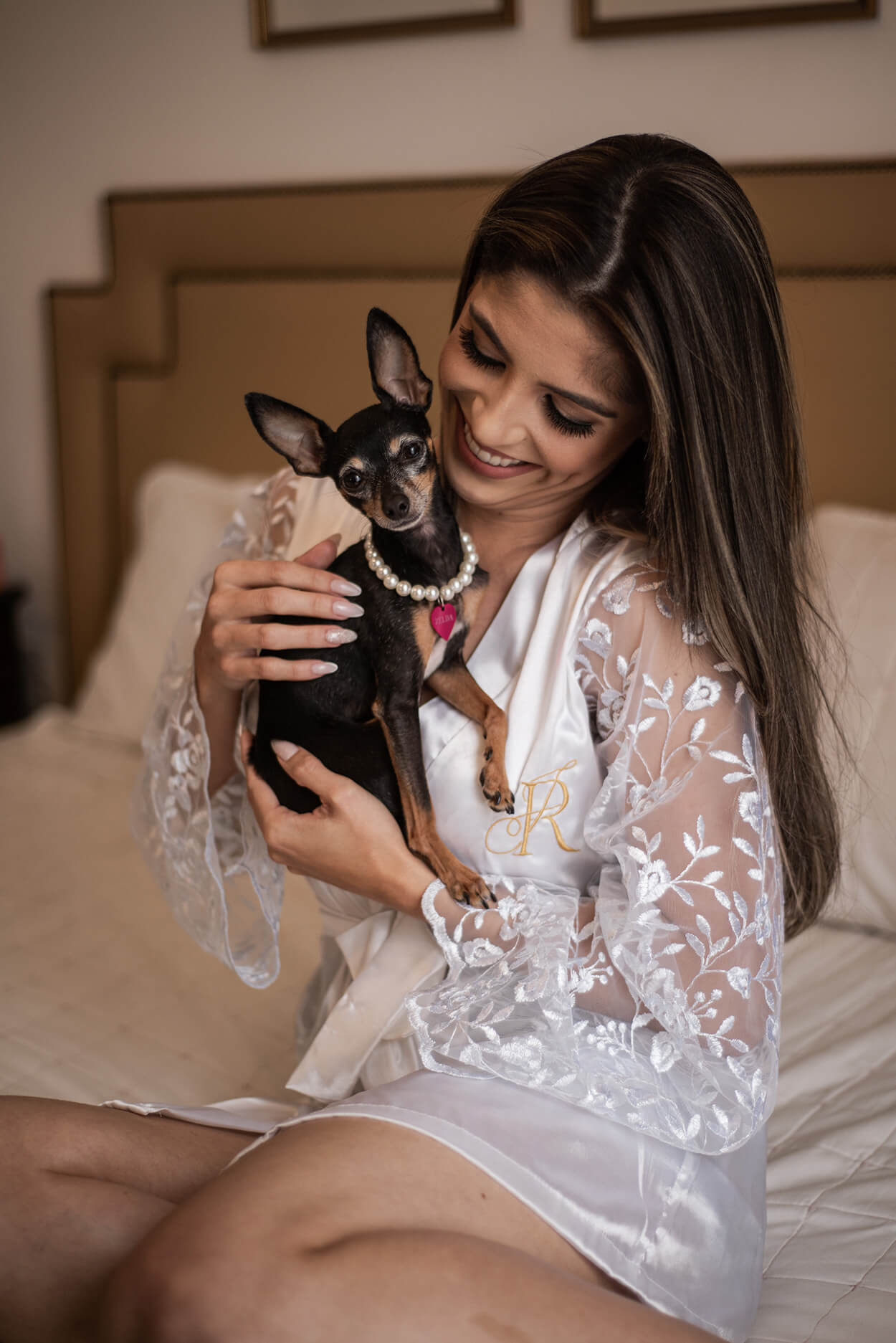 Noiva com robe branco segurando cachorrinha no colo