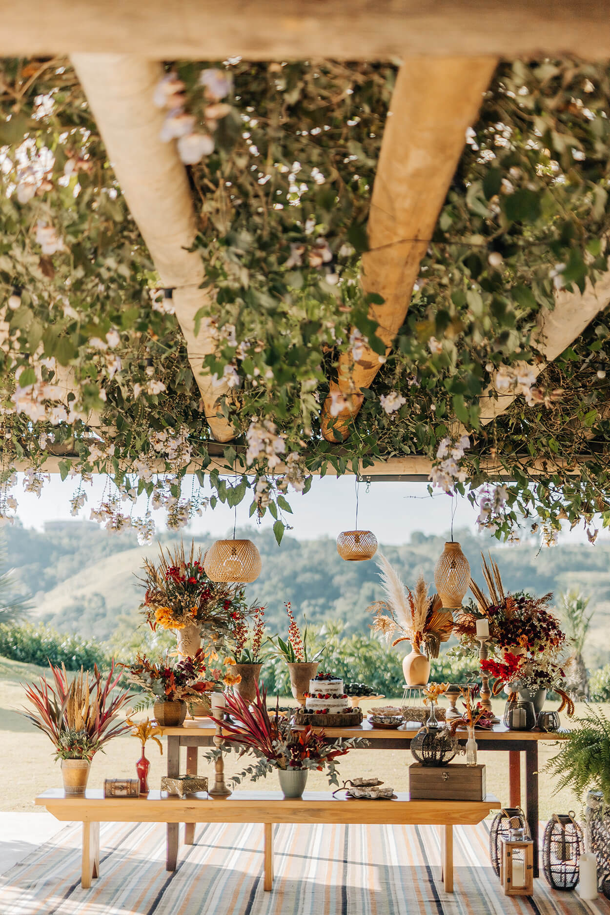 mesas com bolo de casamento vaso com flores e plantas na varanda