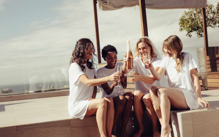 noiva e amigas ao lado de piscina brindando na despedida de solteira