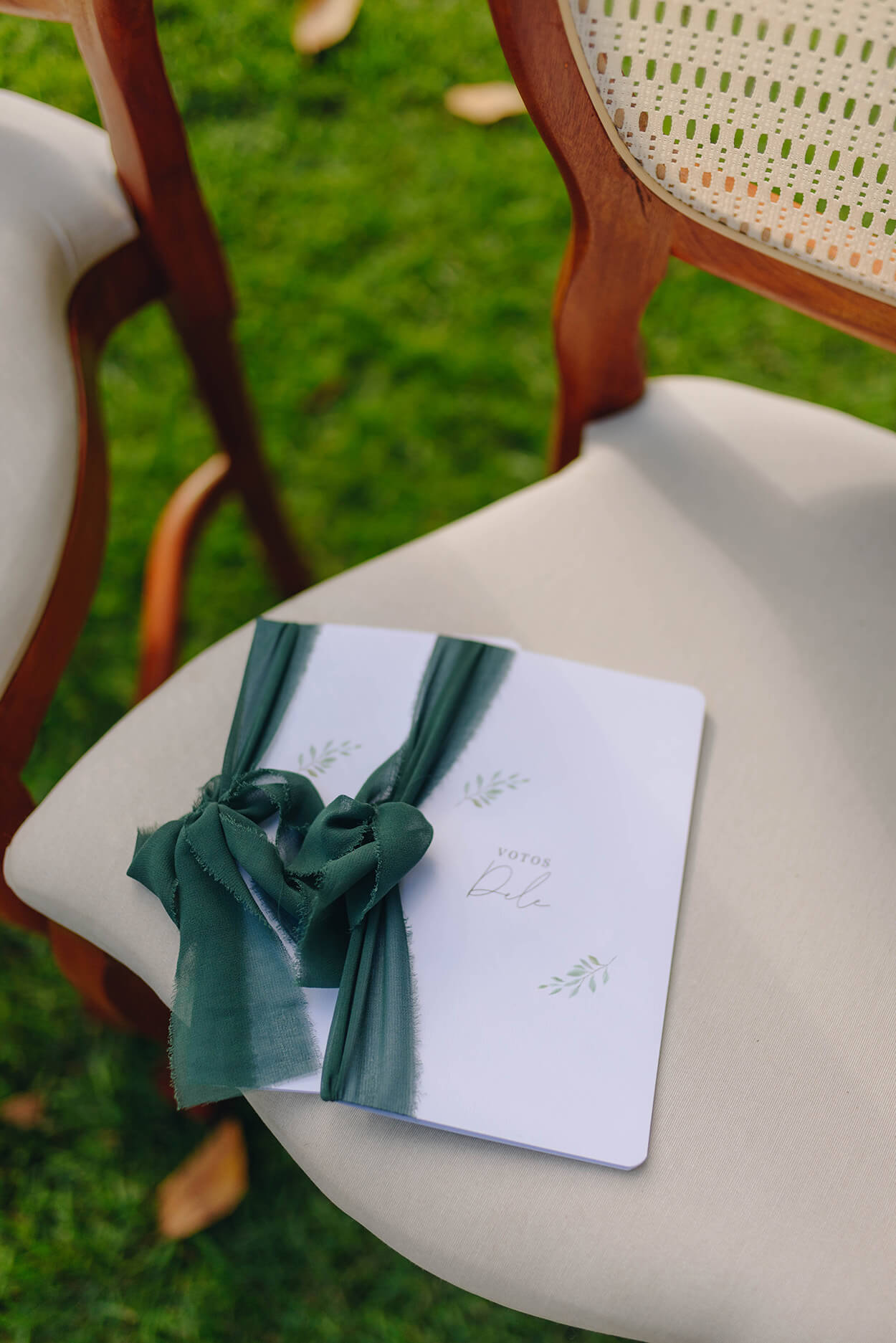 cadernos de votos brancos com laço verde em cima da cadeira