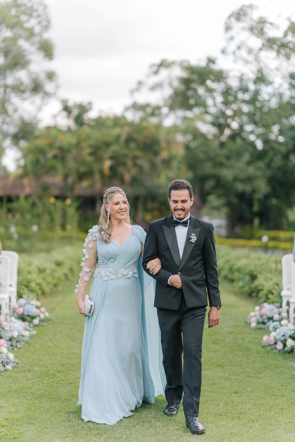 entrada do noivo ao lado da mãe com vestido azul claro