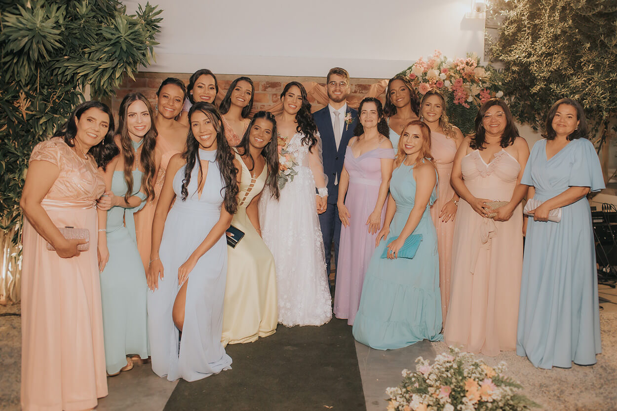noivos ao lado das madrinhas com vestidos coloridos pastel