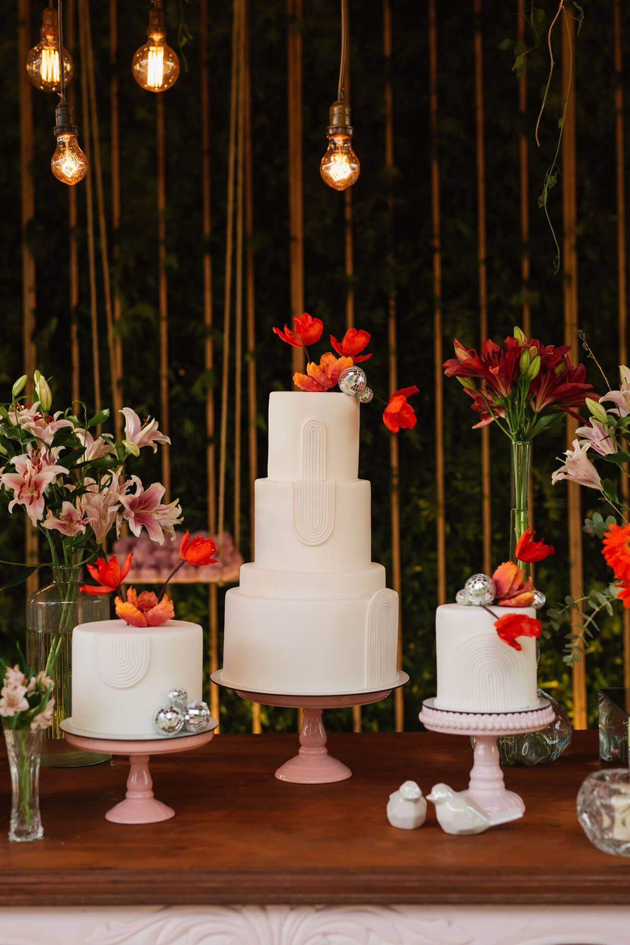 mesa com três bolos de casamento