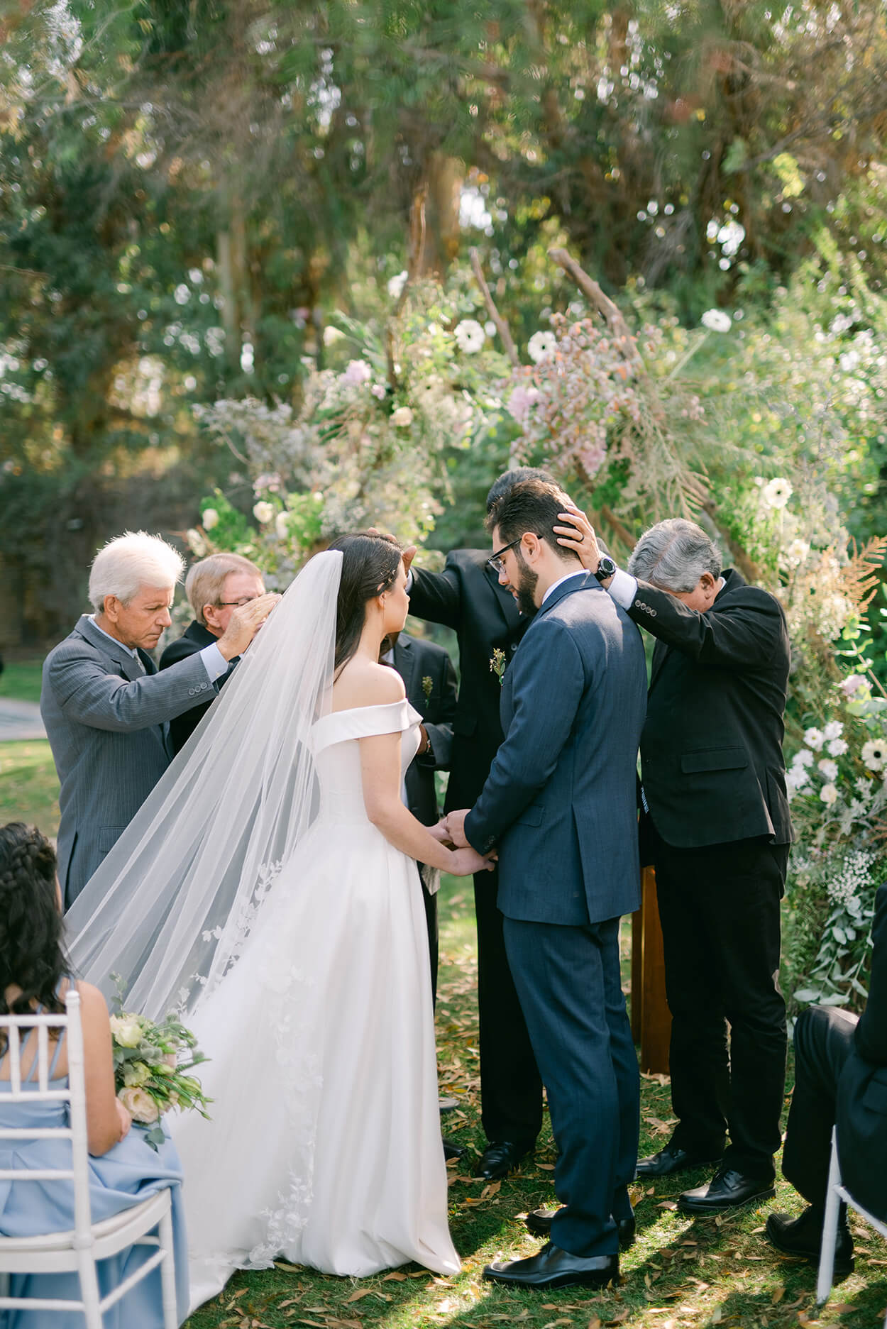 homens orando para os noivos durante a cerimônia de casamento