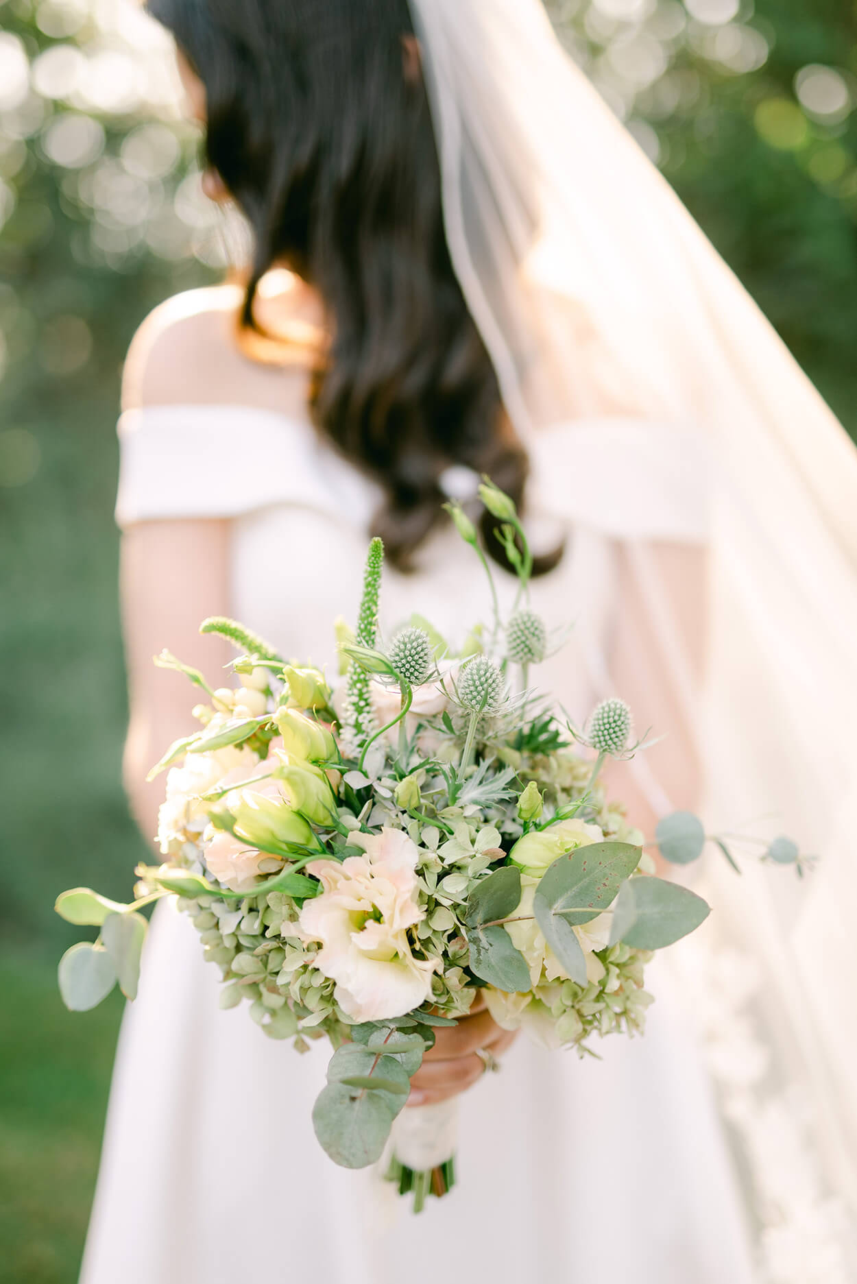 noiva segurando buquê com flores brancas