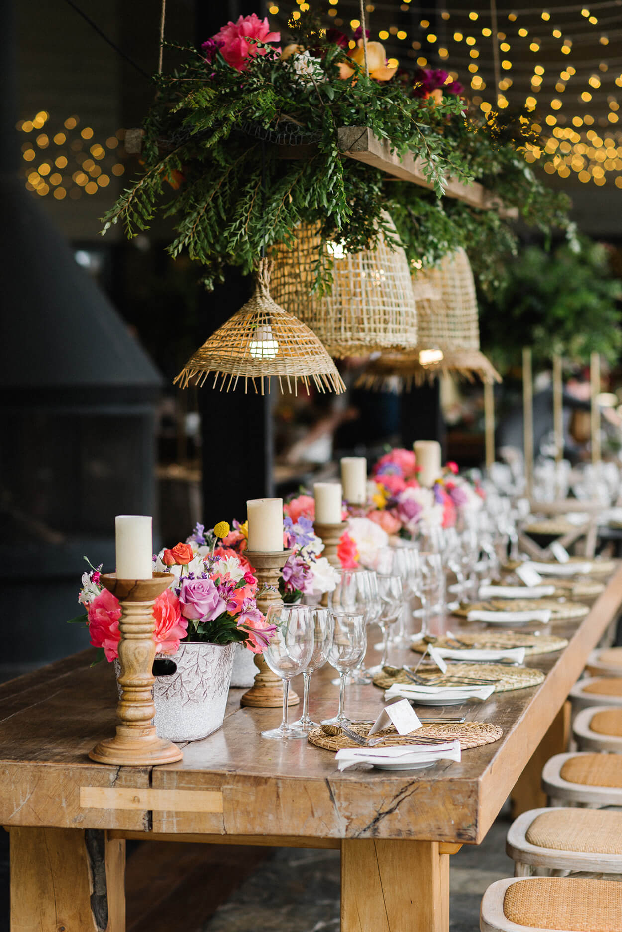 mesa posta com vasos com flores rosas brancas e lilás no centro
