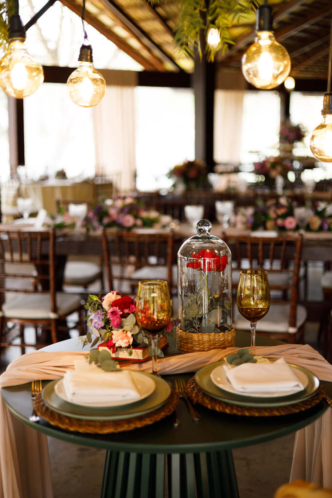 mesa dos noivos verde com flores vermelhas no centro
