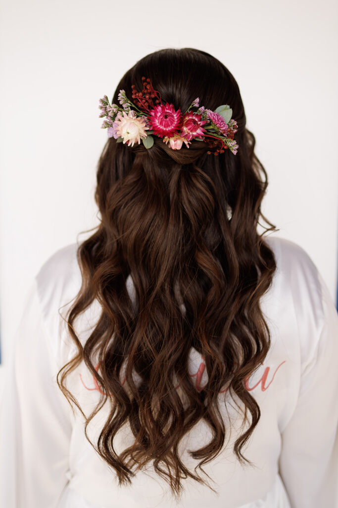 noiva com cabelo semi preso ondulado com flores rosas e brancas na grinalda