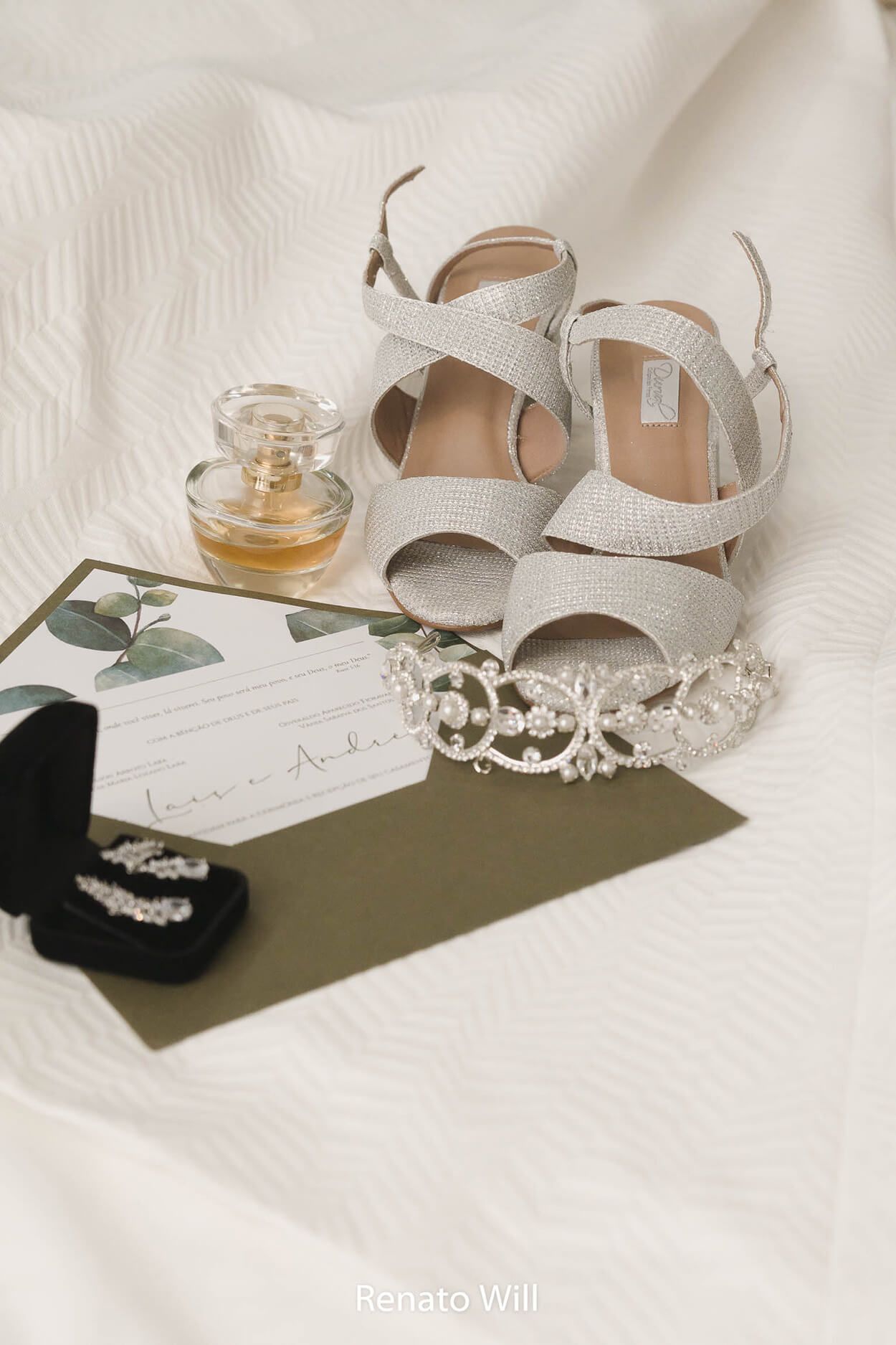 sandália prata ao lado de tiara brincos perfume convite de casamento com envelope verde